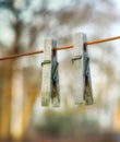 Two wooden washing pegs on a line.Two old wooden clothespins hanging on a washing line in a sunny garden. Old fashioned Royalty Free Stock Photo