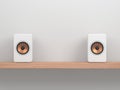 Two wooden white speakers with golden speaker driverWhite speakers with golden speaker driver on Wooden shelf Royalty Free Stock Photo