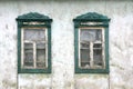 Two wooden windows in abandoned old countryside house. View of an old-fashioned house in the village. Close-up Royalty Free Stock Photo