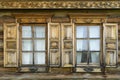 Two wooden windows with shutters on wall of old village house close-up Royalty Free Stock Photo
