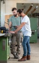 Two worker in a carpenter`s workshop with computer and clipboard Royalty Free Stock Photo
