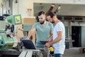 Two worker in a carpenter`s workshop with computer and clipboard Royalty Free Stock Photo