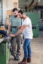 Two worker in a carpenter`s workshop with computer and clipboard Royalty Free Stock Photo
