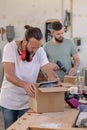 Two worker in a carpenter`s workshop with parcel Royalty Free Stock Photo