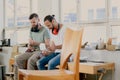 Two worker in a carpenter`s workshop taking a break Royalty Free Stock Photo