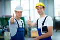 Two worker in factory with thumb up