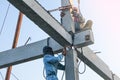 two worker man climbing high concrete pile for welding steel house structure in construction site