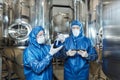 Two workers doing tests at chemical factory and wearing protective suits Royalty Free Stock Photo