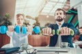 Two workers exercising with dumbbells in office. Royalty Free Stock Photo