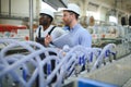 Two workers at a factory for the production of plastic windows. Engineer and worker on the production line Royalty Free Stock Photo