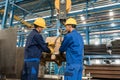 Two workers handling heavy loading lifted by crane