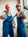 Two workers, holding a hammer and a sledgehammer in their hands Royalty Free Stock Photo