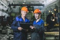 Two workers at an industrial plant with a tablet in hand, working together manufacturing activities Royalty Free Stock Photo