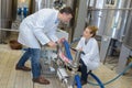 Two workers in lab coats showing their dairy production process