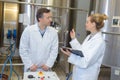 Two workers in labcoat working at factory