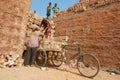 Two workers load bicycle with bricks n Dhaka, Bangladesh.