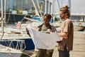 Two workers looking at blueprints in yacht docks