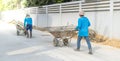 Two worker man pullinng the cement cart for mixing the cement for building the road for the public area Royalty Free Stock Photo