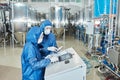 Two workers operating equipment at factory and using control panel Royalty Free Stock Photo