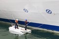 Two workers paint board of cruise liner Royalty Free Stock Photo