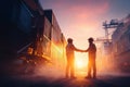 Workers Shaking Hands at Sunset in Industrial Shipping Yard with Containers Royalty Free Stock Photo