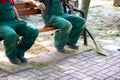 Construction workers rest on a bench after doing hard work.