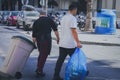 Two workers taking away garbage on the street of a hotel complex in a resort in Greece