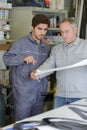 Two workers talking while holding papers and ruler Royalty Free Stock Photo