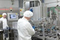 Two workers in uniforms at production line in plant