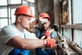Two builders remove old plaster from a brick wall Royalty Free Stock Photo