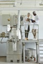 Of two workers wearing lab coats using laptop in clean factory workshop Royalty Free Stock Photo