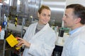 Two workers in white uniforms at production line in plant Royalty Free Stock Photo