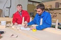 Two workers at a wooden workbench