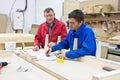 Two workers at a wooden workbench