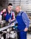 Two workers working on machine