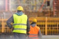 Two workers in yellow and orange at the construction site Royalty Free Stock Photo