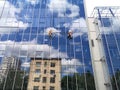 Two working climbers on a glass wall of a high-rise building Royalty Free Stock Photo