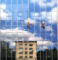 Two working climbers on a glass wall of a high-rise building Royalty Free Stock Photo