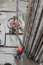 Two working drillers install a drill pipe raised from the well. Royalty Free Stock Photo