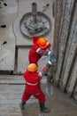 A working driller installs a drill pipe raised from a well. Royalty Free Stock Photo