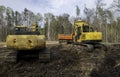 Two working excavators and one orange dump truck Royalty Free Stock Photo