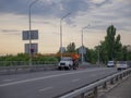 Two working men on a mobile aerial platform of a crane truck on a road bridge