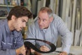 Two workmen conferring over paperwork