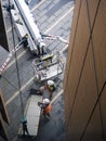 Two workmen preparing hoisting operation of a building panel using a mechanical crane