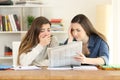 Two worried students reading a newspaper