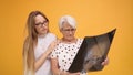 Two worried women, young and senior holding a x-ray o MRI head scan