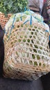 two woven bamboo baskets containing green celery and light green cabbage tied with blue raffia