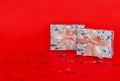 Two wrapped gift boxes with pink satin ribbons and bows on red background Royalty Free Stock Photo