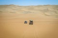 Two 4x4 driving in the Namibian desert.