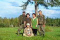 Two Yakut Asian elderly couples men and women with a young girl sitting on the grass pose for a family photo in a field